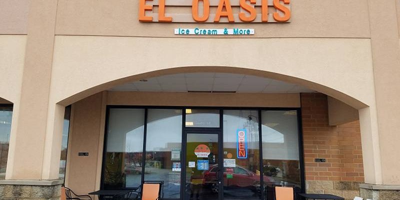 The entrance of El Oasis with a glass door set near a front of glass windows. Photo by Matthew Macomber.