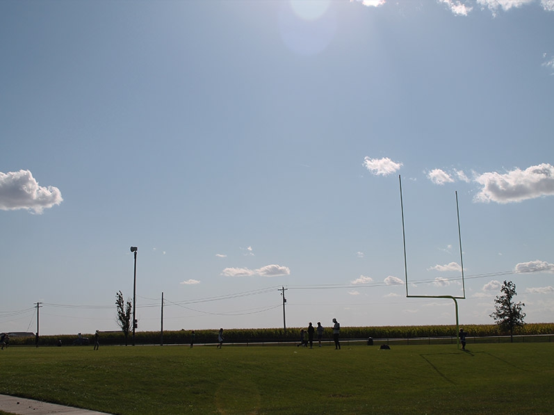 people playing on a football field with goalposts