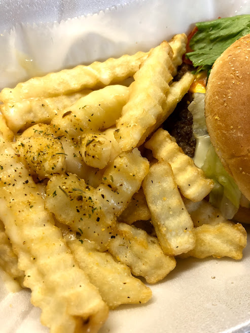 A close up of seasoned fries and a burger from Come Get This food truck. Photo by Remington Rock.