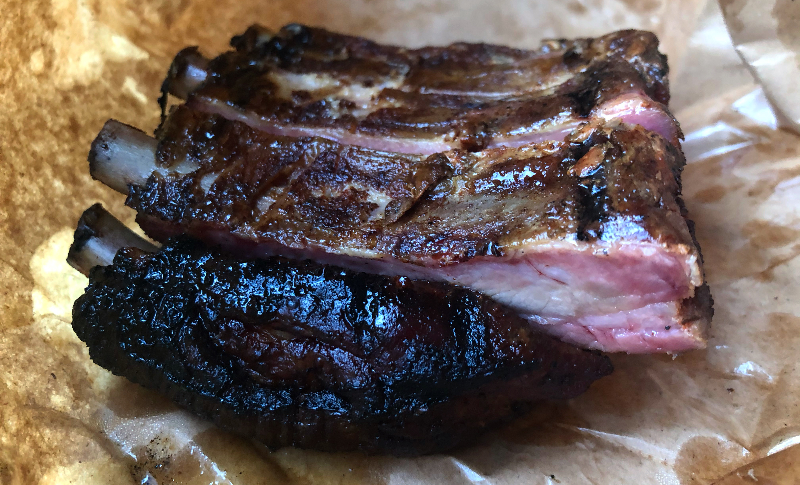 A half slab of ribs from Black Dog in Champaign are in brown piece of parchment paper. Photo by Alyssa Buckley.