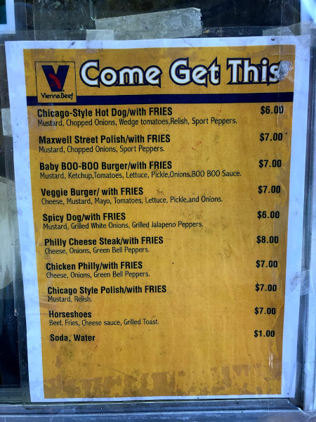 A photo of Come Get This food truck's menu on a yellow background with black text. Photo by Remington Rock.