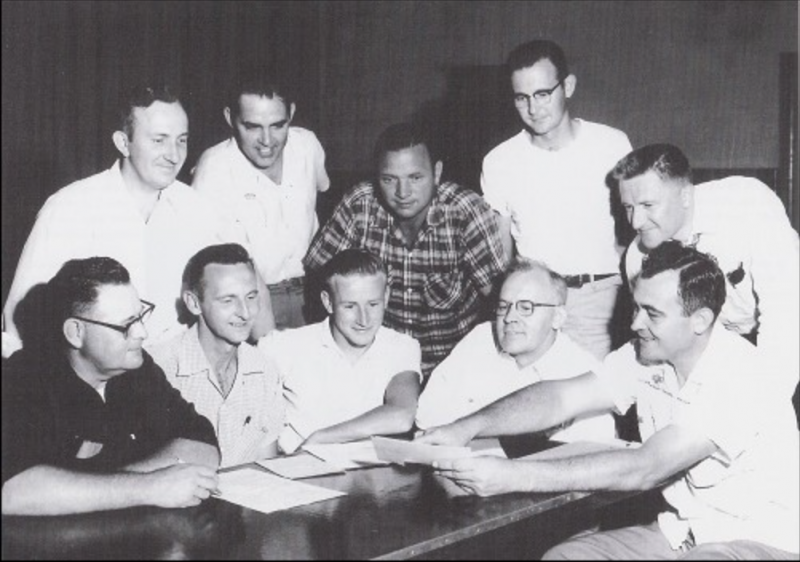 a group of extremely white men sit at a table posturing about their lives 