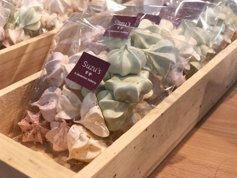 Muted, colorful meringues are sealed in a bag labeled Suzu's at Suzu's bakery in Downtown Champaign. Photo by Alyssa Buckley.