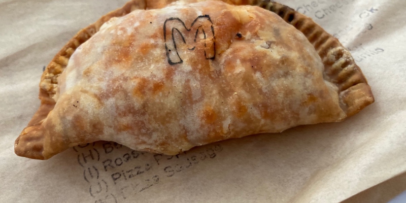 One empanada from Manolo's. The empanada is stamped with the letter M to indicate the flavor. Photo by Anthony Erlinger. 