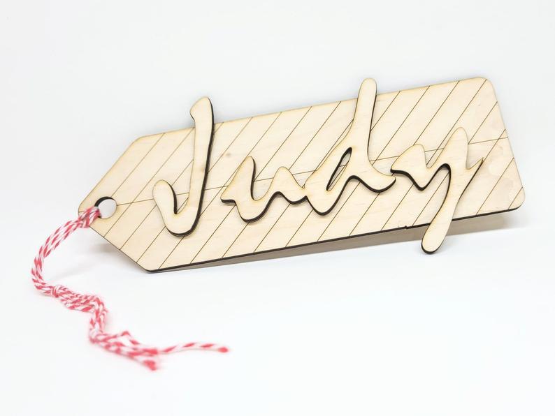 A wooden ornament tag with a string attached and the name Judy displayed. Photo courtesy of Judy Lee and Made in Urbana