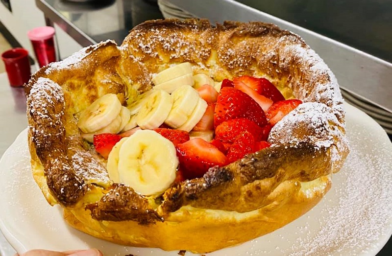  A Dutch Baby filled with bananas, strawberries, and powdered sugar contained in a bowl-shaped piece of cooked dough. Photo courtesy of Original Pancake House in Champaign