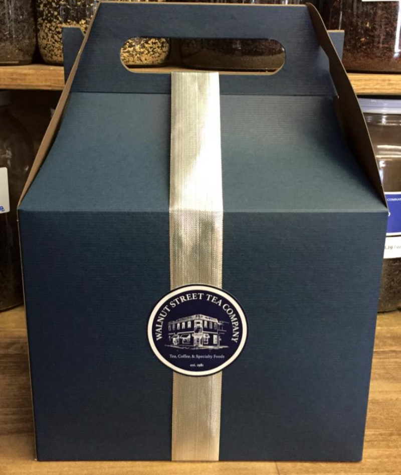 A black cardboard box has a circular sticker reading Walnut Street Tea Company with a golden ribbon. Photo from Walnut Street Tea Company's Facebook page.