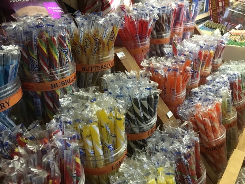 A variety of hard candy sticks on a shelf with the butterscotch, tangerine, and bubblegum labels shown. Photo provided by Walnut Street Tea Company.