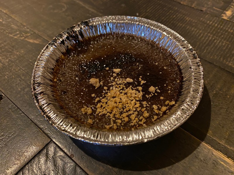 A round aluminum container is filled with a chocolate creme brulee, and crumbly topping. Photo by Julie McClure.