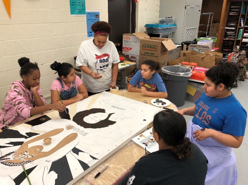 Members of the Sisterhood Academy at work on the inner door mural panel. Photo courtesy of the Museum of the Grand Prairie.