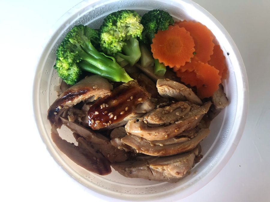 An overhead shot of Siam Terrace's chicken teriyaki rice bowl. There is a lot of dark meat chicken with a little sauce next to steamed broccoli and carrots. Photo by Alyssa Buckley.