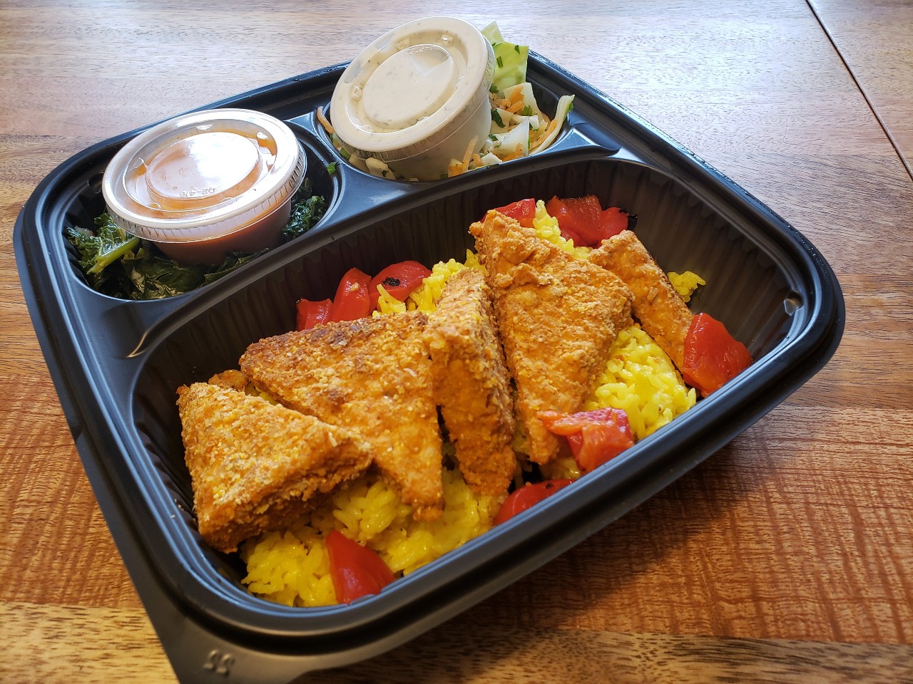 A Red Herring meal includes crusted tofu and two small carryout cups of sauce. Photo by Sara Ressing.