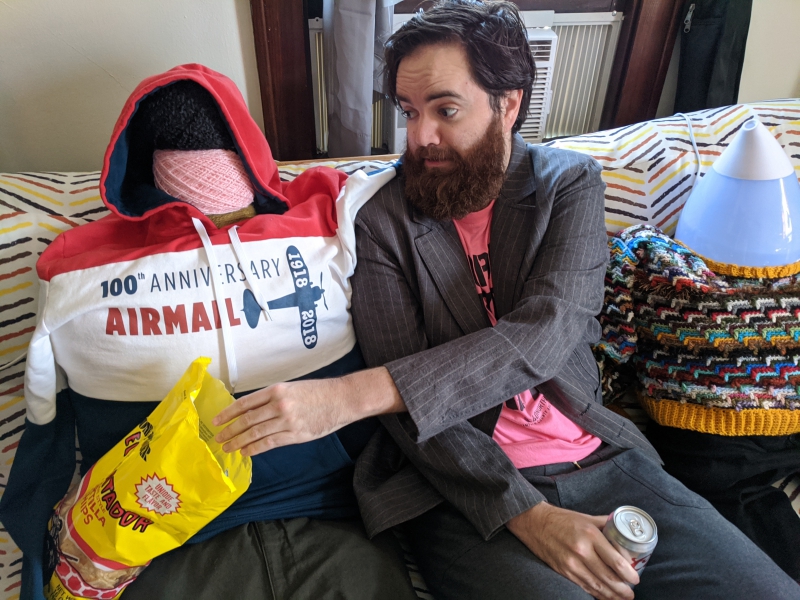 The writer is reaching into a bag of chips on the fake person's lap, with a frightened look on his face. Photo by Andrea Black.