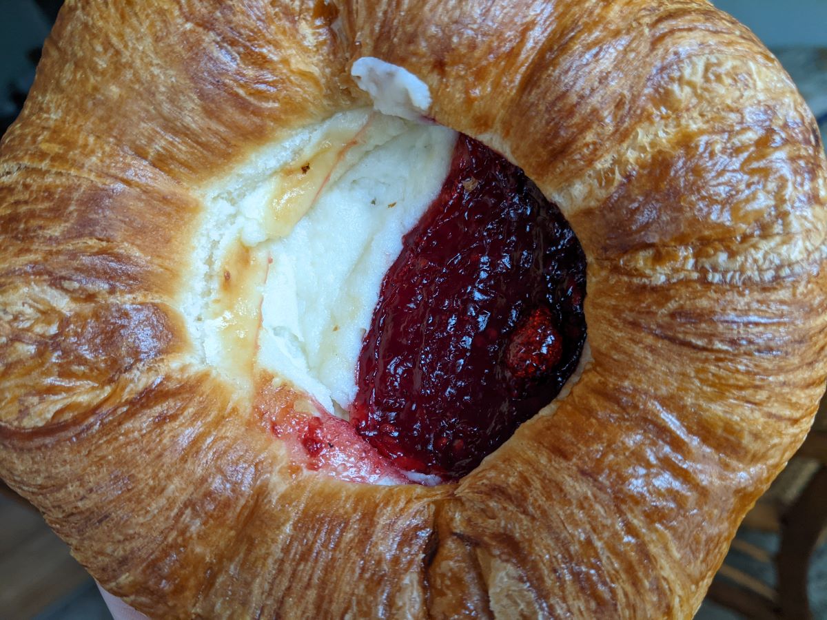 Raspberry Cream Cheese Danish from CI Bakehouse. A round danish, puffed pastry on the outer ring, white cream cheese and red raspberry preserves in the center. Photo by Tias Paul.