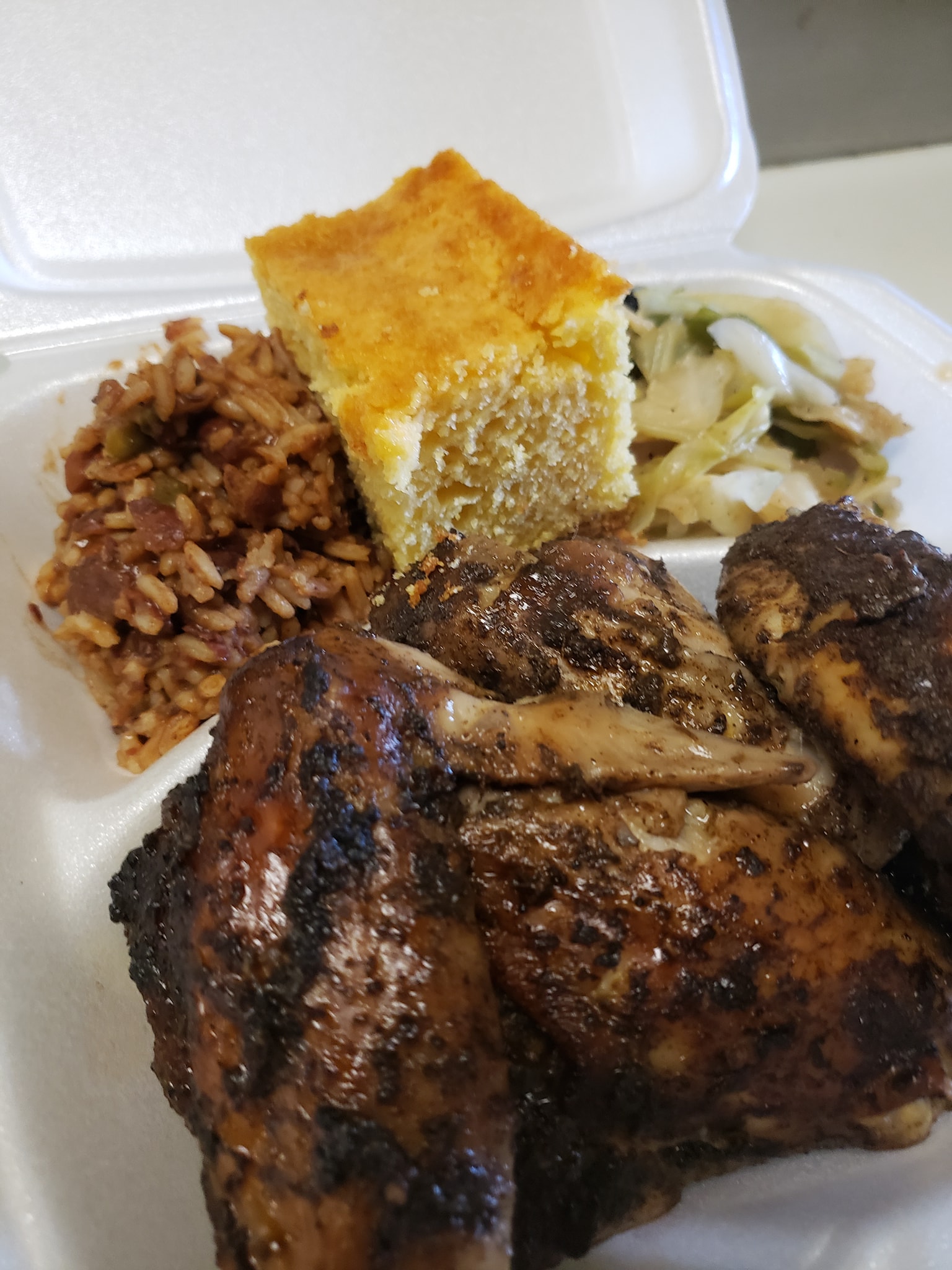 Seasoned chicken with two sides sits in a divided styrofoam container. Photo from Dis N' Dat BBQ Facebook page.