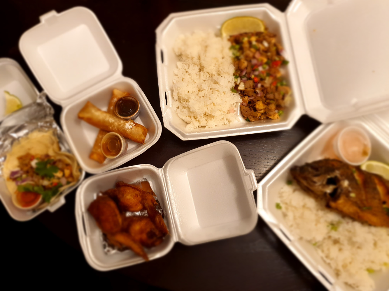 An overhead image of takeout from A Taste of Both Worlds with all the food in a variety of sizes of Styrofoam containers. Photo by Da Yeon Eom.