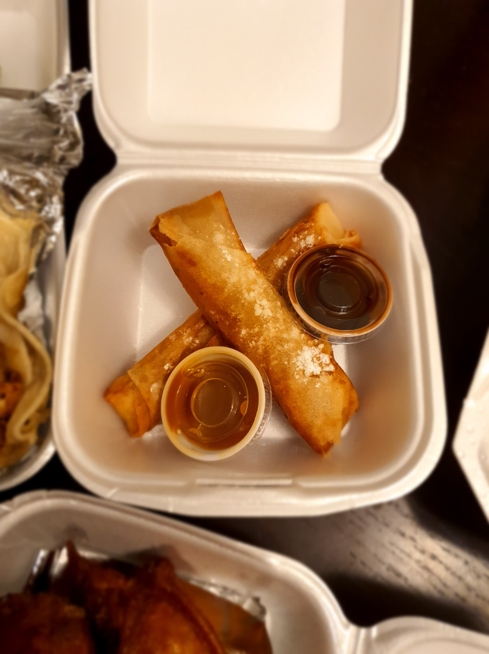 Two dessert turons sit in a takeout container with two dipping sauces. Photo by Da Yeon Eom.