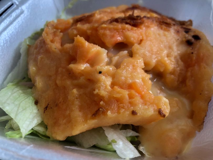 A close up of llapingachos from El Paraiso shows the orange potato dish with light yellow queso dripping out. Photo by Alyssa Buckley.