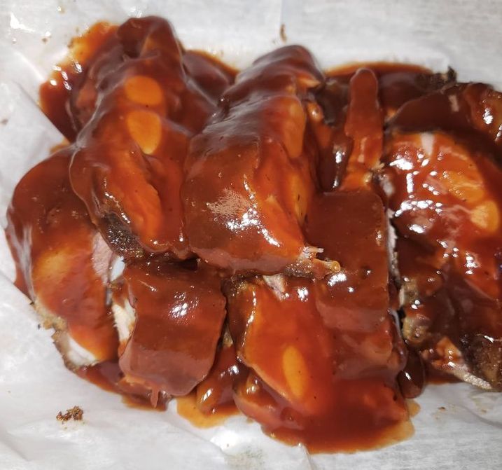 Rib tips from Dis N' Dat BBQ are covered in a dark barbecue sauce. Photo from Dis N' Dat BBQ Facebook page.