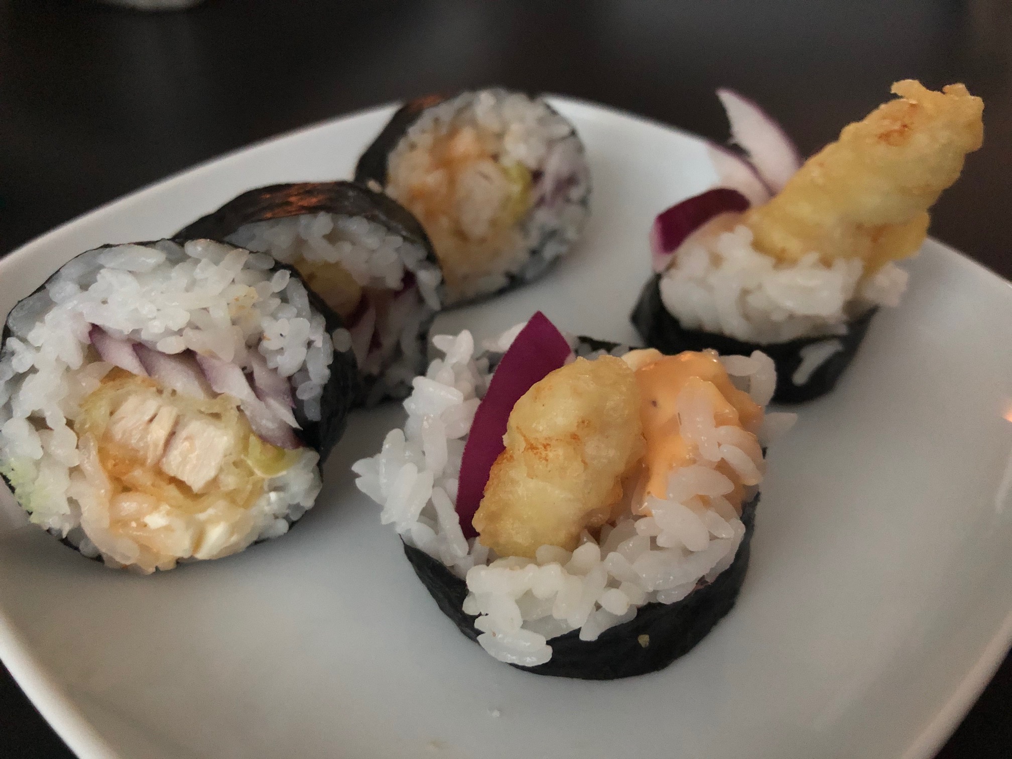 A photo of the chicken run roll from Sushi Kame: five sushi pieces with red onion, fried chicken, and rice. Photo by Alyssa Buckley.