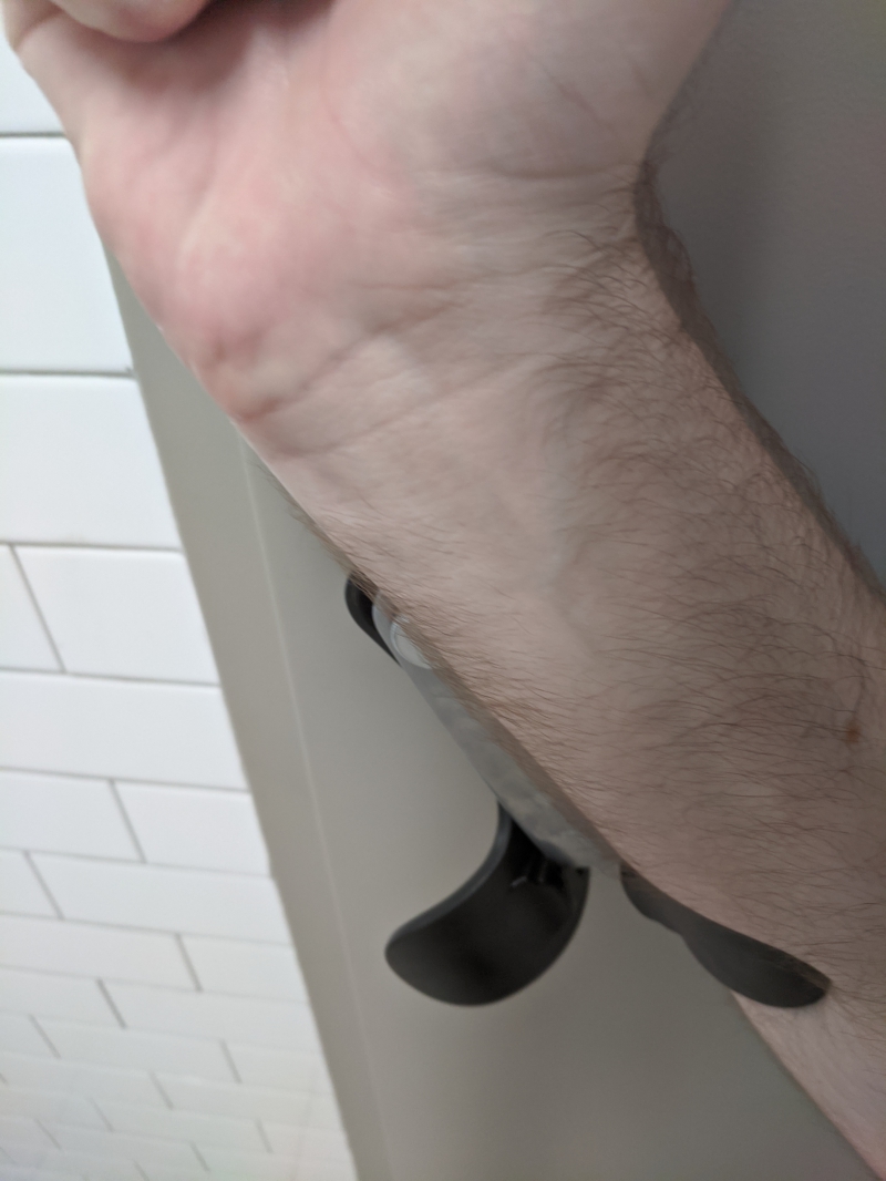 A close up of an arm resting against the black door handle implement. Photo by Tom Ackerman.