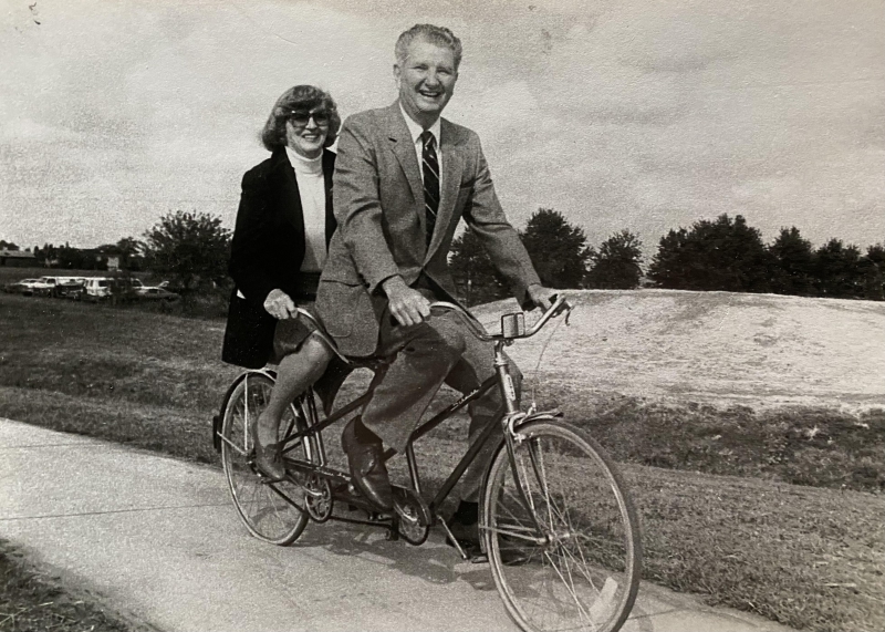 a man and woman couple on a tandem bicycle in black and white 