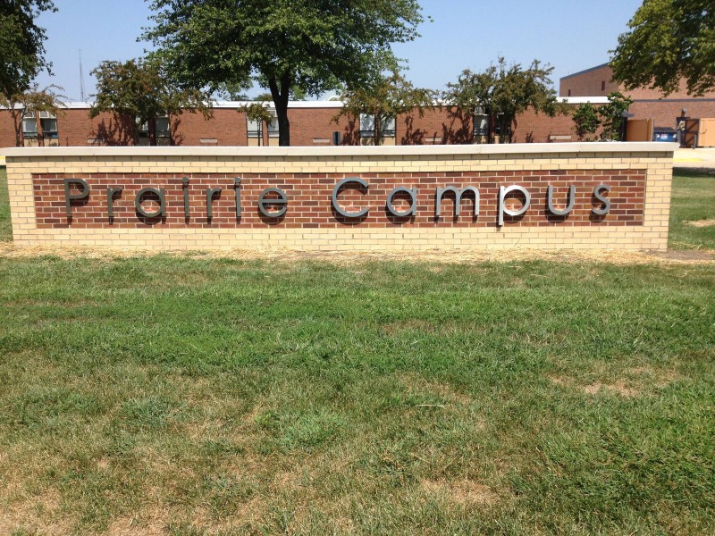 A red brick and concrete sign says Prairie Campus in metal lettering. It sits in the grass in front of a red brick building. Photo from Dr. Preston L. Williams PTA Facebook page. 
