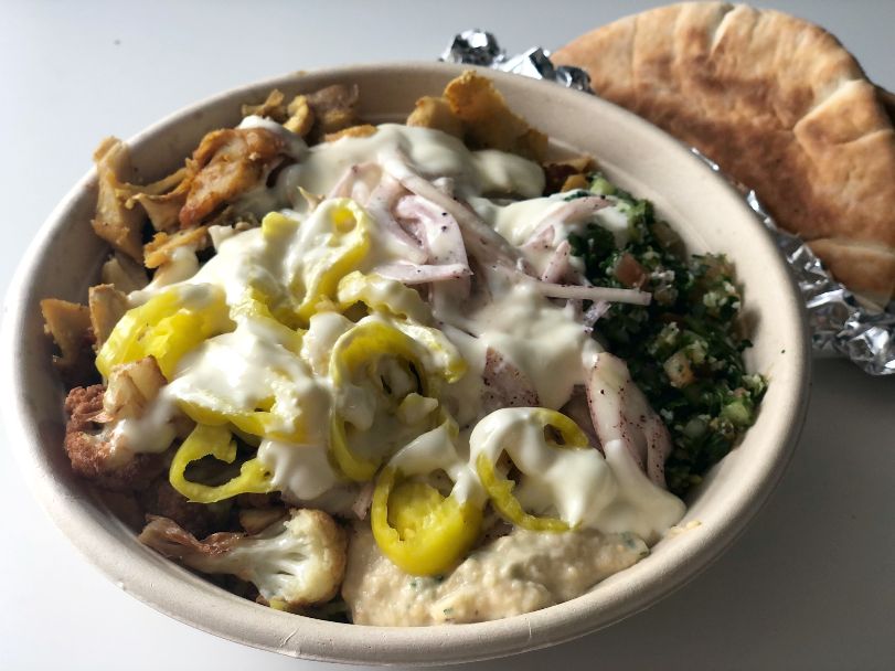 A chicken bowl from Shawarma Joint has chicken, rice, banana peppers, cauliflower, and a white sauce on top. Photo by Alyssa Buckley.