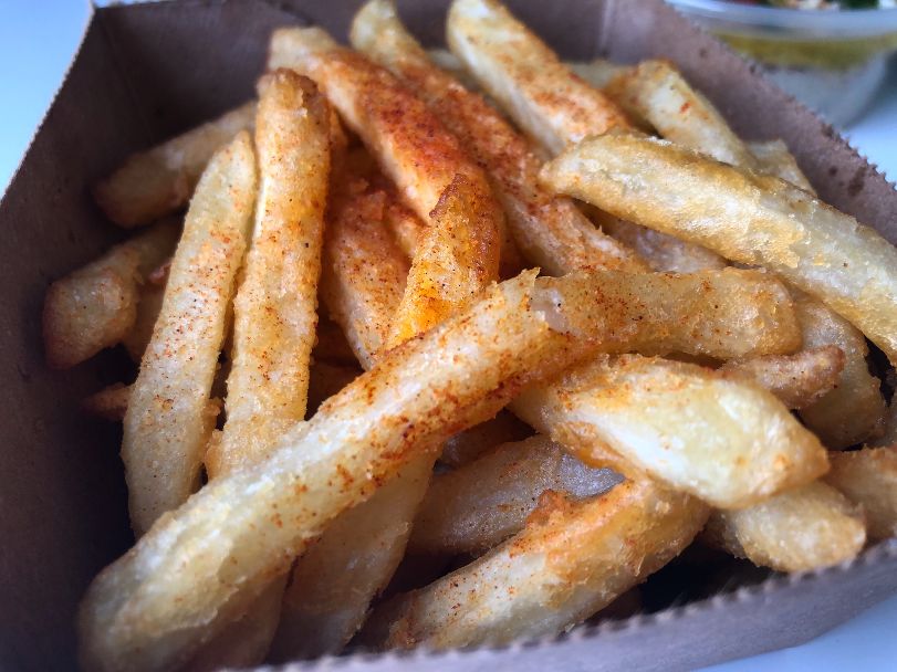 A paper basket of fries from Shawarma Joint shows a close up on the fries with a reddish seasoning. Photo by Alyssa Buckley.
