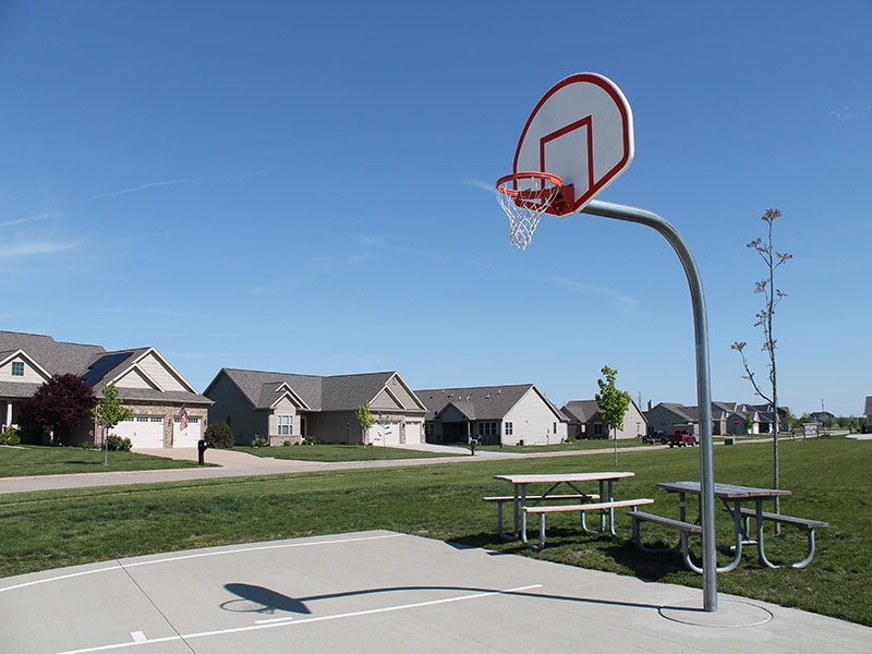 a basketball hoop with picnic tables around it 