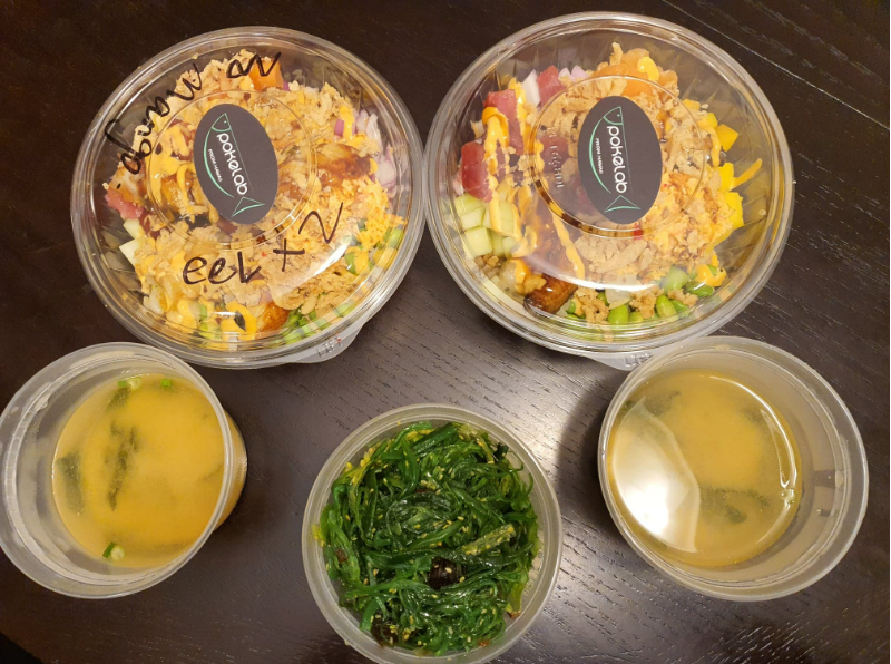An overhead photo of the author's dinner with two customized poke bowls, two bowls of miso soup, and a seaweed salad. Photo by Da Yeon Eom.