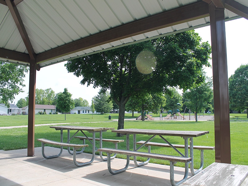 picnic tables under a shelter in a park 