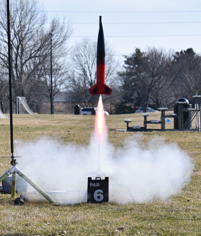 A large, traditional model rocket takes off in a cascade of flame and smoke. Photo by Christopher Brian Deem.