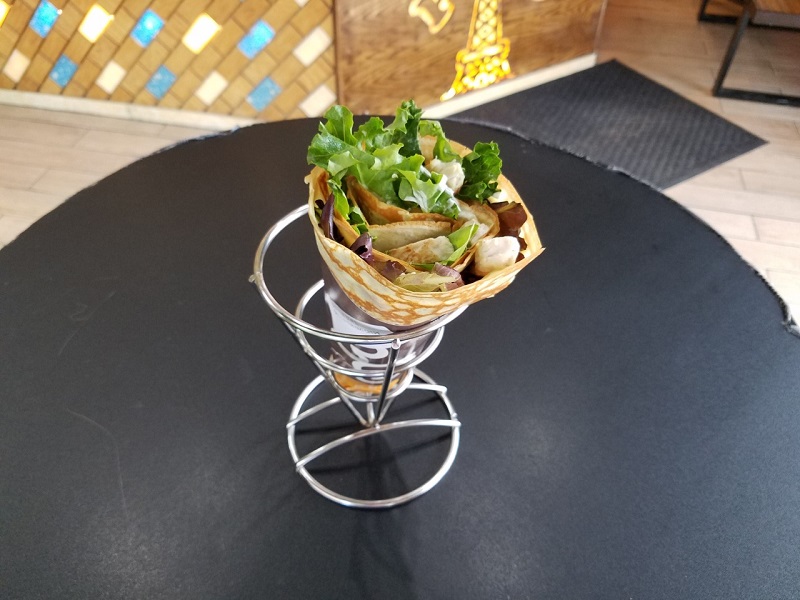 Chicken teriyaki crÈ‡pe rolled into a cone and held in a metal cone structure. Photo by Matthew Macomber.