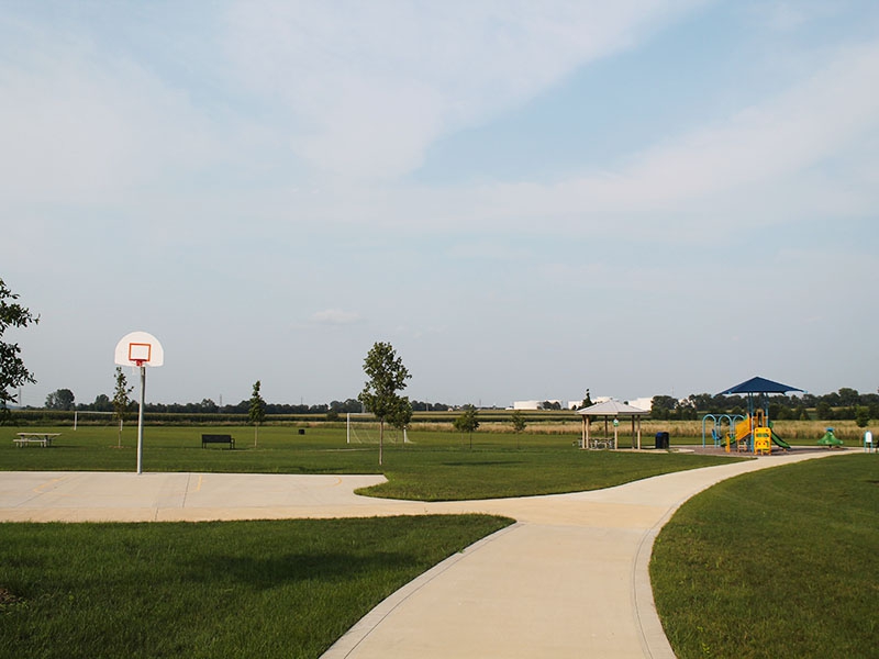 a basketball court and walking path in a park