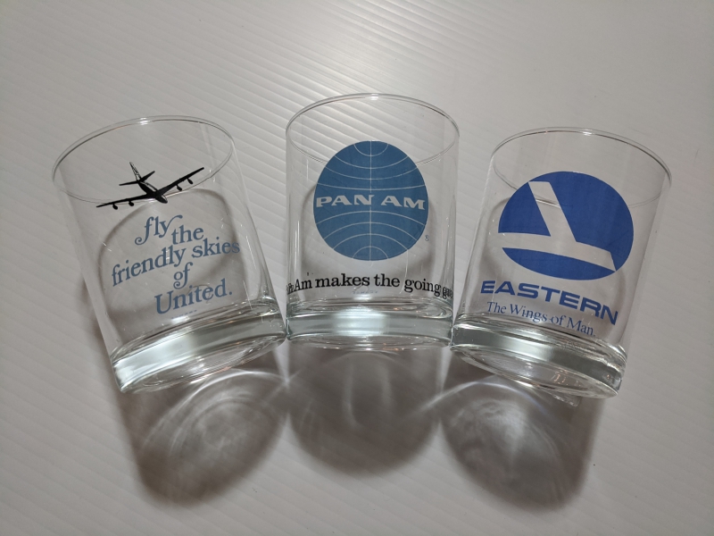 Three clear glasses with airline logos in blue. Photo by Tom Ackerman. 
