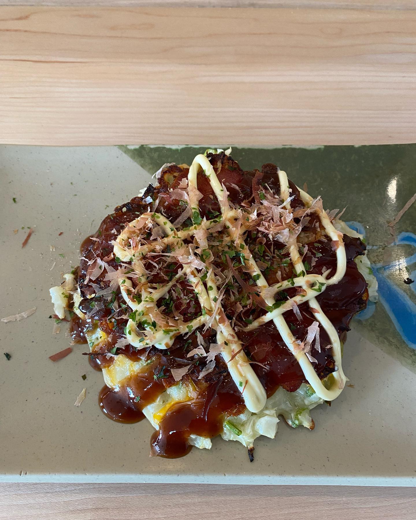 On a metal plate, there is a special dish from the new restaurant ISHI in Champaign. The dish is topped with lines of sauce and little microgreens. Photo by Ken Ishibashi.