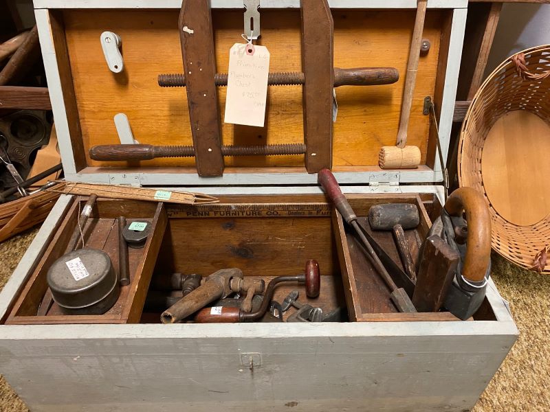 An open wooden box filled with metal and wooden tools. Photo by Julie McClure.
