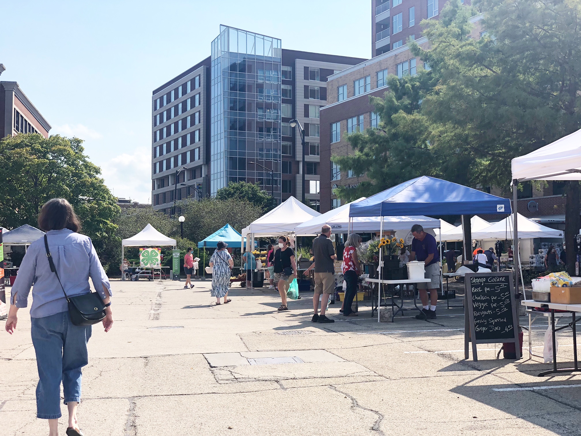 On a sunny Tuesday afternoon, shoppers are shopping the vendors at the Champaign Farmers' Market. Photo by Alyssa Buckley.