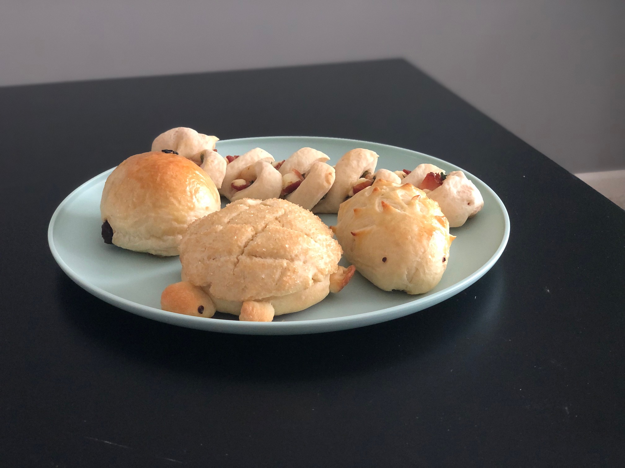 On a teal plate, there are several Japanese baked goods including two that are shaped like animals. Photo by Alyssa Buckley.