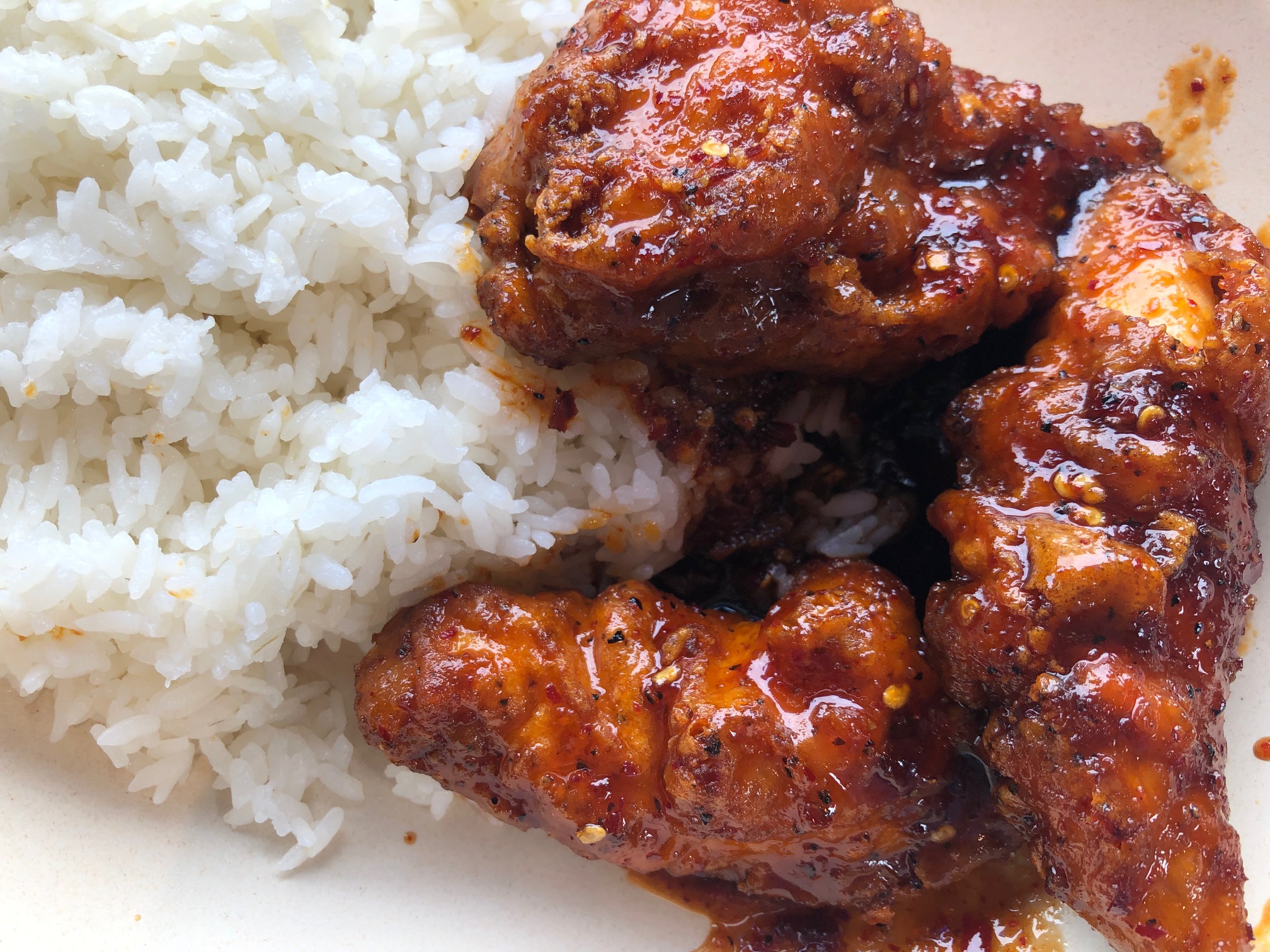 Spicy, saucy Korean chicken is on white steamed rice. Photo by Alyssa Buckley.