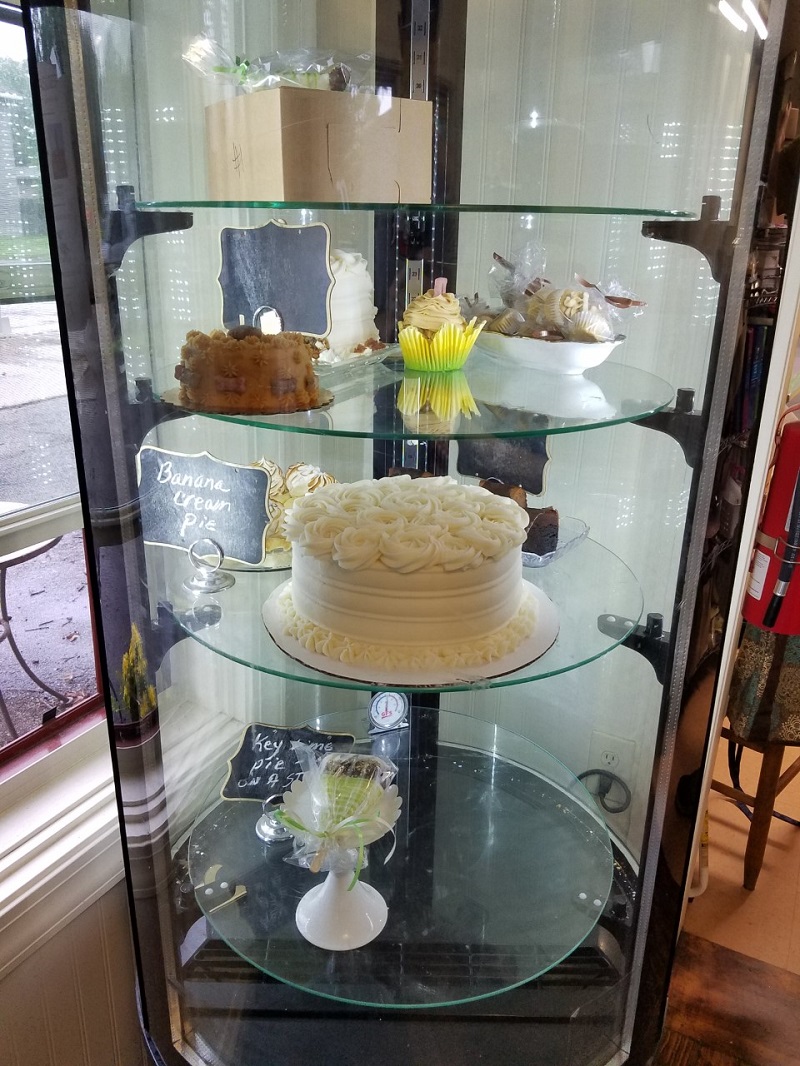 A cylindrical display case containing various pies and cakes, some of which are made for pets to eat. Photo by Matthew Macomber.