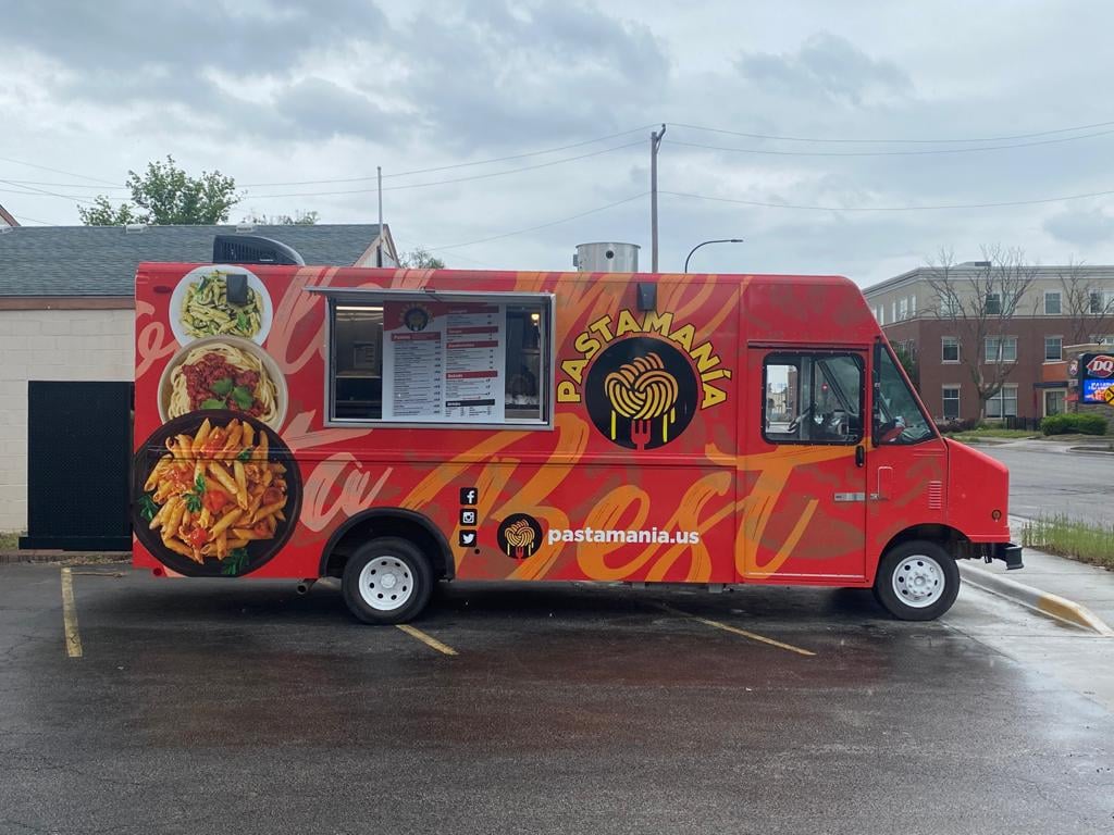 Parked in three parking spots, the PastaMania truck is red with images of bowls of pasta on the outside. Photo by PastaMania.