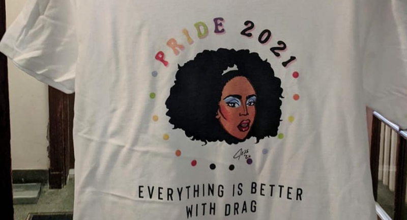A white t shirt with the cartoon face of Karma Carrington. The shirt says Pride 2021 in rainbow colors as well as 