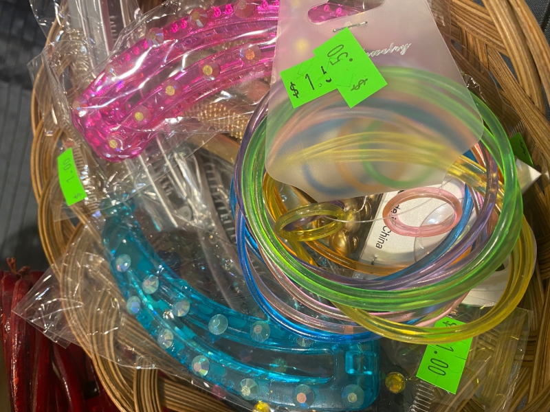A basket filled with colorful thin rubber bracelets, and different colored hair clips with rhinestones. Photo by Julie McClure.