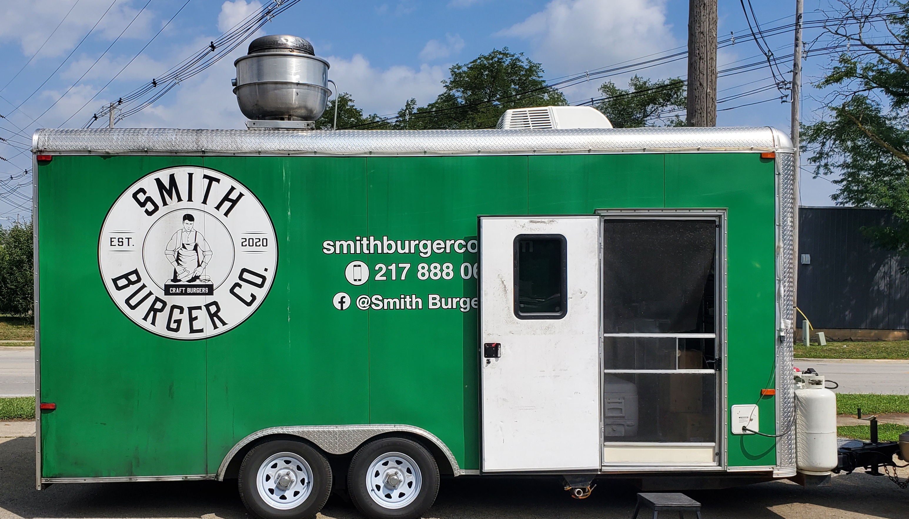 A green trailer for the food truck Smith Burger Co has the business' logo, phone number, and social media handles. Photo by Carl Busch.