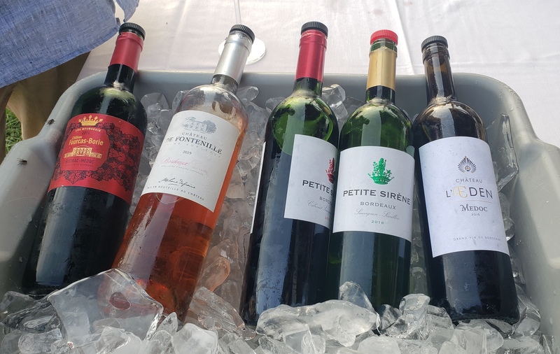 Five wines from Louis Dressner/France locations are presented on a bed of ice in a gray tub. The wines are labled from various wineries mostly in French language. From left: Chateau L'Eden Medoc; Fontenille RosÃ© Entre-Deux-Mers; Petite Sirene Roug; Petite Sirene Blanc; and  Chateau Fourcas Borie Listrac-Medoc. Photo by Sara Ressing.