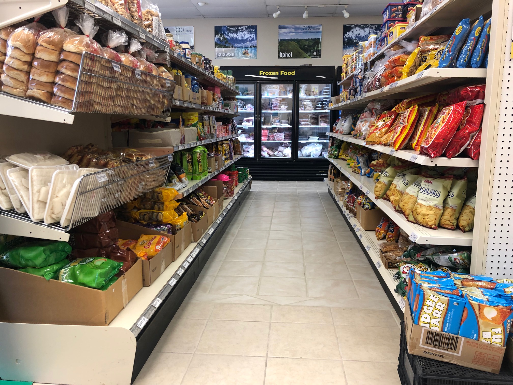 This photo shows the entire snack aisle at Maligaya's store. On the left, there are breads and other sweets, and on the right, there are colorful bags of savory snacks. Photo by Alyssa Buckley.