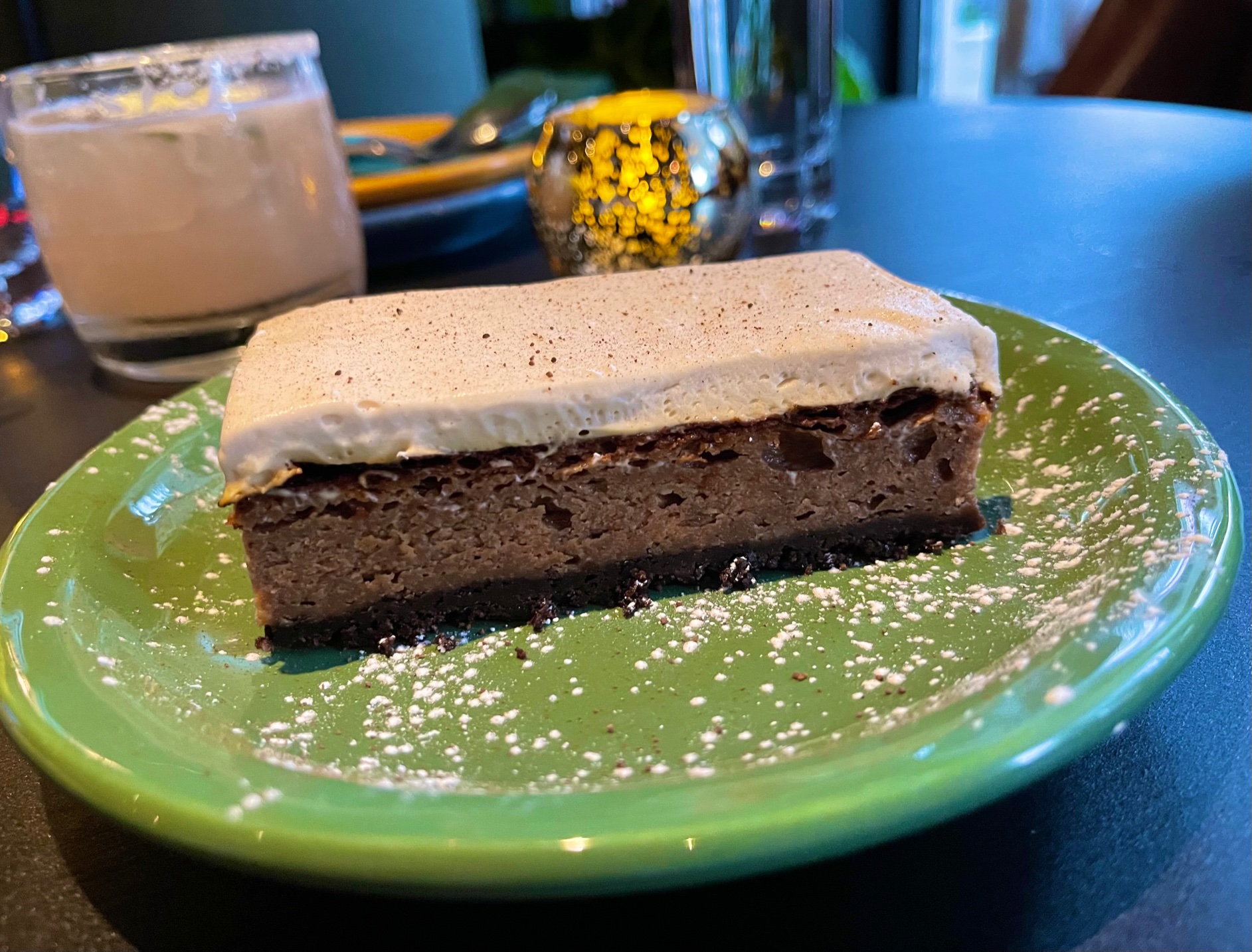 On a green plate, there is a Russian bar with layers of chocolate and a white frosting. Photo by Stephanie Wheatley.