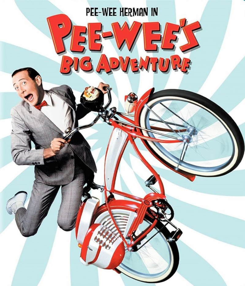 An image from a movie poster. It has a light blue and white striped background, and Pee Wee's Big Adventure spelled out in red block letters. There is an image of the title character in a gray suit and red bow tie hanging on to a red and white bicycle. Image from The Virginia Theatre Facebook page.